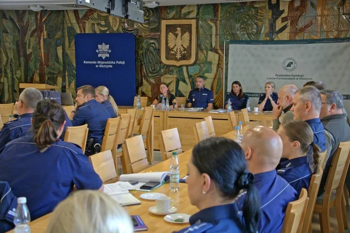 Funkcjonariusze policji i przedstawiciele Regionalnej Dyrekcji Lasów Państwowych w Olsztynie uczestniczą w spotkaniu w siedzibie Komendy Wojewódzkiej Policji w
